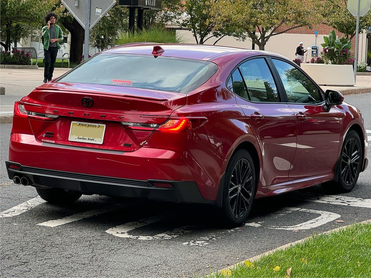 Red 2025 Toyota Camry viewed from the rear side